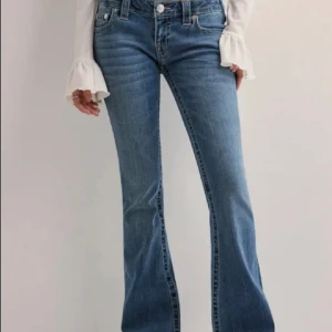 Blå bootcut jeans från True Religion - Snygga blå jeans från True Religion med klassiska kontrastsömmar och ikoniska bakfickor. Modellen har bootcut-ben, normal midja och är tillverkad i mjukt denimtyg. Perfekta för dig som gillar en tidlös och trendig look.