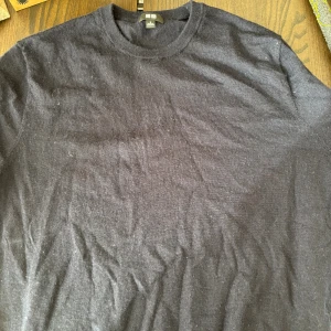 Svart stickad tröja från Uniqlo - En stilren svart stickad tröja från Uniqlo i storlek S. Tröjan har rund halsringning och långa ärmar, perfekt för lager-på-lager. Materialet är merinoull och ger en skön känsla mot huden. Enkel design som funkar till många olika looks.