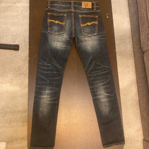 Nudie jeans med slitningar  - Ett par överföra nudie jeans med snygga designade slitningar. Modell thin finn storlek 28/33. Sitter slim/regular på mig som är 177/60kg. Jeansen har en skitsnygg tvätt och är i nyskick utan någon som helst defekt. Har du frågor om fler bilder mått osv? Fråga på!