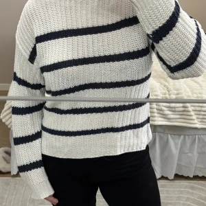 Randig stickad tröja - Vit stickad tröja med mörkblå ränder från Lager157. Använd väl men inga skador. Storlek S, större i storleken. Vid frågor är de bara att skriva.