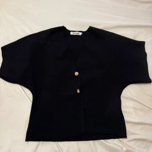 Jeans klänning med knappar och krage - Snygg jeansklänning i blå denim med korta ärmar, klassisk krage och knappar hela vägen framtill. Två bröstfickor med lock ger en cool touch. Figurnära passform som framhäver siluetten och passar perfekt till sneakers eller boots.