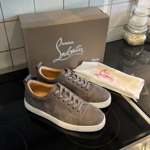 Christian loubotin skor  - Snygga grå sneakers från Christian Louboutin i mjuk mocka med den ikoniska röda sulan. Skorna är helt nya och extremt snygga. Vid minsta fundering om pris mm är det bara att skriva.