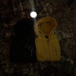 Sail Racing fleecehoodies gul & mörkblå S - Säljer två feta hoodies från Sail Racing i storlek S, en i knallig gul och en i mörkblå. Båda har dragkedja, huva och broderad logga på bröstet. Mjukt fleecematerial på insidan gör dem extra sköna. Perfekta för dig som vill ha en chill och sportig stil. Använda några gånger men i perfekt skick.