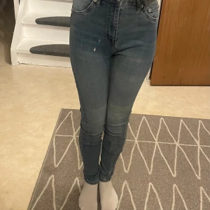Blå skinny jeans från 157, storlek S - Säljer ett par blå skinny jeans från 157 i storlek S. Jeansen är högmidjade med klassisk femficksdesign och dragkedja. De har en tight passform och är tillverkade i stretchigt denim för en bekväm känsla. Perfekta för dig som gillar en smal siluett.