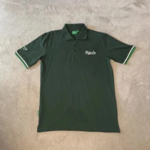 Grön Carlsberg pikétröja - Säljer en mörkgrön pikétröja från Carlsberg med vit logga på bröstet och ärmen. Aldrig använd bara testad, går ej att få tag på. Size:M