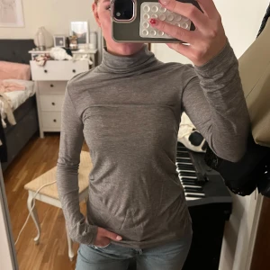 Grå polotröja från Zara - Slimmad grå polotröja från Zara i mjuk bomullsblandning. Långärmad modell med klassisk polokrage och enkel, stilren look. Perfekt att styla med jeans eller under en jacka för lager-på-lager vibe.