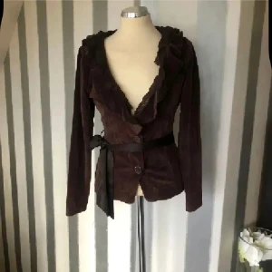 Brun tröja  med volangkrage - Snygg brun topp i mjuk sammet med volangkrage och knytband i midjan. Djup v-ringning, långa ärmar och två knappar framtill. Perfekt för dig som vill ha en unik och trendig jacka med extra detaljer.