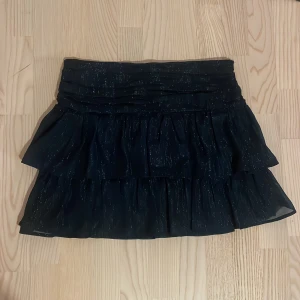 Blå glittrig kjol - Jag säljer en blå glittrig kjol,  jag har använt den en gång till nyår förra året men efter det har den tyvärr inte kommit till användning. Storleken är 170 men jag skulle säga att den passar ngn som är s/m