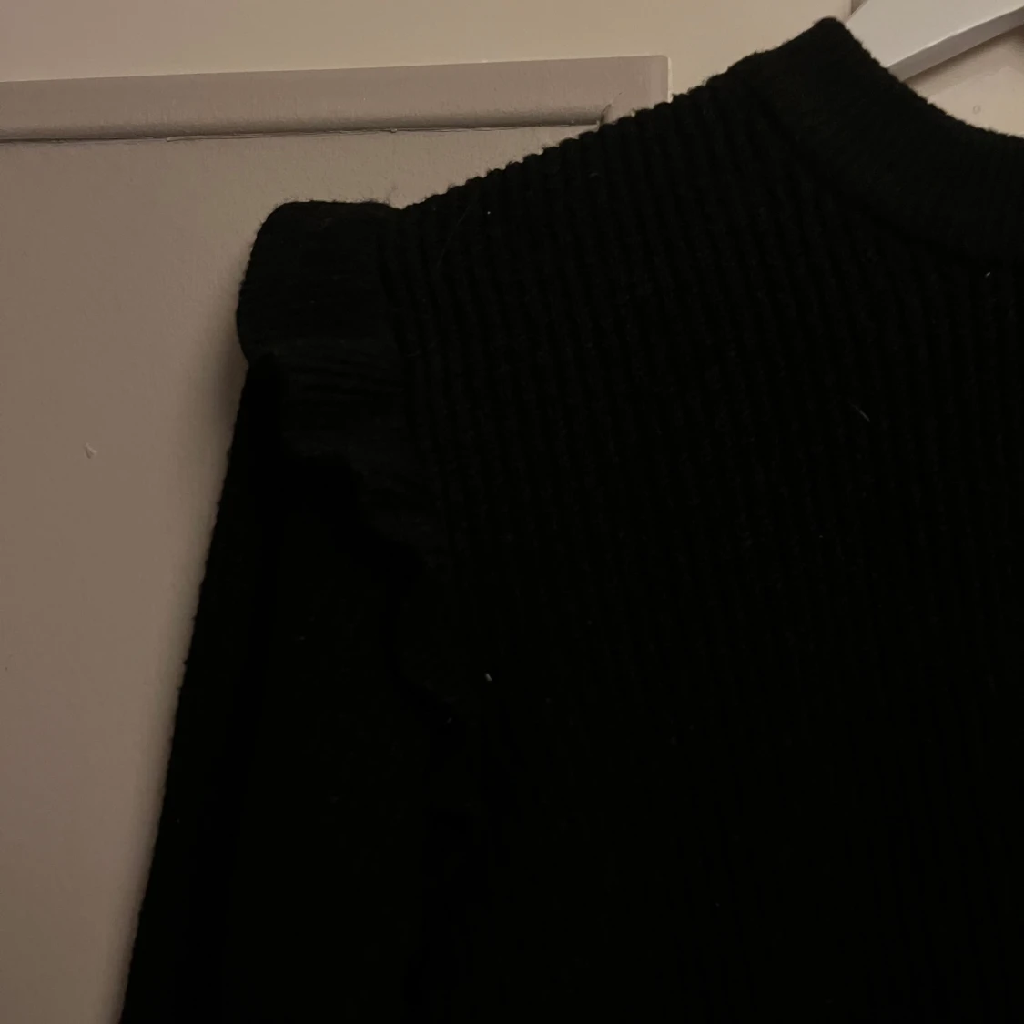 Svart stickad tröja med volanger - 1