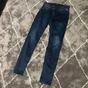 Mörkblå jeans från Replay (luzien) - W 27, längden på byxorna 96cm. Snygga mörkblå  jeans från Replay i modellen Luzien. Klassisk femficksdesign, dragkedja och knapp framtill samt diskret Replay-logga vid fickan. Jeansen har en bra  passform och är gjorda i stretchigt jeansmaterial för extra komfort.