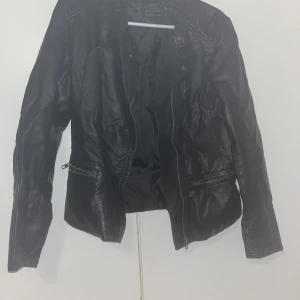 Keinonahkatakki 38 - Musta käytetty keinonahkatakki. Sisällä ohuehko vuorikangas. Sisällä ja takana niskassa pientä nahkan irtoilua. Koko 38. Kaikai n 47cm, pituus n 57cm. Eläintalous MMM, lisätietoja saa kysymällä Katso myös muut ilmoitukseni Tarjoa 