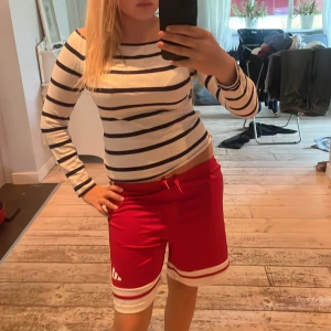 Randig långärmad tröja från H&M - Säljer en vit långärmad tröja från H&M med marinblå horisontella ränder. Tröjan har en klassisk, lite båtringad hals och är i mjuk bomull. Perfekt för en chill och stilren look.