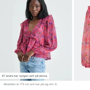 Blommig rosa blus med volang - Supersöt blommig blus i rosa och lila toner med v-ringning och volangdetaljer. Långa puffiga ärmar och luftig passform ger en romantisk vibe. Perfekt att styla med jeans eller kjol för en färgglad look.