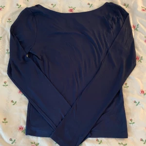 Marinblå långärmad topp Gina Tricot - Svart långärmad topp från Gina Tricot med djup, rundad urringning i ryggen. Enkel och stilren design i mjukt material, perfekt att matcha med jeans eller kjol. Snygg passform och klassisk look. Har aldrig använts!