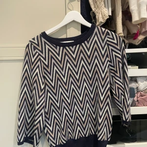 Mönstrad stickad tröja med zigzag från neo noir - Säljer en stickad tröja från Neo noir Knit med snyggt zigzag-mönster i svart, beige och vitt. Tröjan har rund halsringning och trekvartsärmar. Perfekt för dig som gillar grafiska mönster och vill sticka ut lite extra. PRIS GÅR ATT DISKUTERA 