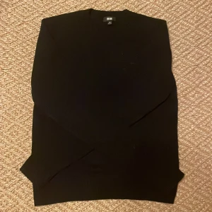 Svart stickad tröja från Uniqlo XS - En klassisk svart stickad tröja från Uniqlo i storlek XS. Tröjan har rund halsringning och långa ärmar, perfekt för lager-på-lager. Enkel och stilren design som funkar till allt. Materialet är mjukt och bekvämt.