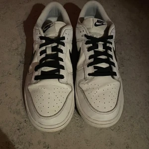 Nike Dunk Low - Vit och Svart - Väldigt fint skick! 8/10, de är använda men väldigt sparaamt.  De är endast använda med creaseskydd, därför har de inga creases. Creaseskydden ingår vid köp, de är i skorna.  De är vårdade och tvättade regelbundet, helt vita och snygga skor. Väldigt bekväma, passar även 42 eller 44.   Hör av er vid fler frågor!!