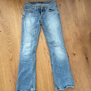 Blå bootcut jeans med slitna detaljer - Snygga blå bootcut jeans med ljus tvätt och slitna kanter nertill. Klassisk femficksmodell med dragkedja och knapp. Skriv ifall intresserad!! 