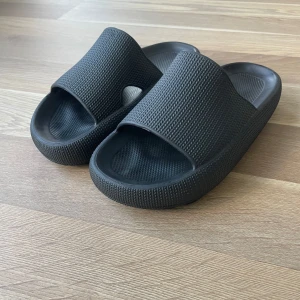 Tofflor - Svarta slides sandaler med bred rem över foten och öppen tå i storlek 42, anvönda få tillfällen