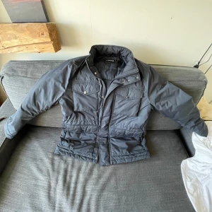 Blå Field jacka från J.Lindeberg M - Snygg Blå Field Jacka från J.Lindeberg i storlek M. Jackan har hög krage, flera fickor med lock och dragkedja framtill. Klassisk logga på ärmen och stilren design som funkar till det mesta. Perfekt för kyliga dagar. Nypris 4000 kr. Använd ett fåtal gånger