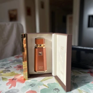Liquid Brun lyxig parfymflaska - Exklusiv parfym från Liquid Brun i en elegant, kopparfärgad flaska med guldiga detaljer. Flaskan har en geometrisk form och levereras i en lyxig presentask med vit insida. Perfekt för dig som gillar unika och stilrena dofter. Har inte använt är hel full 100ml