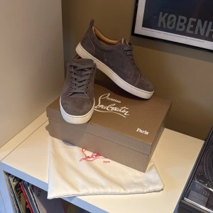 Christian Louboutin  - Snygga grå sneakers i mocka från Christian Louboutin med klassisk röd sula. Storleken på skorna är 42, passar något större. Är i princip helt nya då dom bara används fåtal gånger. Box och Dustbag ingår. OBS priset är inte hugget i sten!!