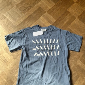 Blå Maison Margiela t-shirt med print - Helt ny maison margiela t shirt i storlek S. väldigt stor i storleken så den sitter mer som M. 1850kr om du köper den här och min andra maison margiela t shirt jag har i min profil!