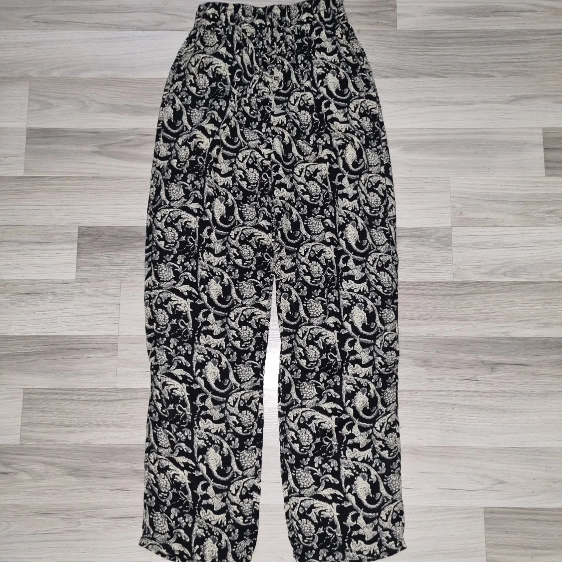 Svarta byxor med blommigt mönster