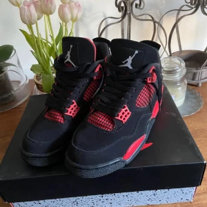 Nike Air Jordan 4 Retro Svart/Röd - Säljer ett par Nike Air Jordan 4 Retro i svart och rött med klassisk Jumpman-logga på plösen och hälen. Skorna har meshpaneler, snörning och detaljer i rött på sidor och sula. Ovandelen är i mocka och syntet, med en chunky siluett och cool streetstil. För flera bilder eller frågor så är de bara att slå ett pling sick 7.5/10 priset kan diskutera vid snabb affär. 