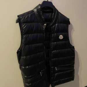 Svart dunväst från Moncler - Hej säljer vidare min väst då den inte kommer till användning för jag har köpt ny. Jätte fin och knappt använd. NFS tag fungerar och tar dig direkt till moncler hem sidan alla lappar och qr kod finns kan skicka mer bilder om så önskas. 