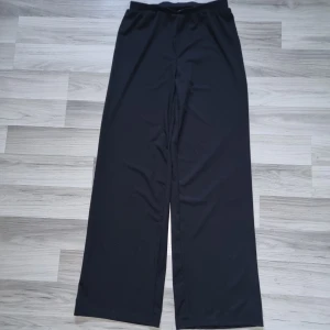 Vida svarta byxor från SHEIN - Byxa från SHEIN i storlek M. Elastisk midja och vida ben för en chill och avslappnad look. Perfekta för dig som gillar bekväma och stilrena byxor.