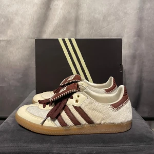 Adidas Wales Bonner - Adidas x Wales Bonner Samba "Pony Tonal" storlek 44 (US 10)  Helt äkta och knappt använda. Inköpt från Sneakersnstuff. Kvitto saknas tyvärr, originalbox och allt som ingick vid köp (inkl. extra skosnören) medföljer.  En unik och eftertraktad modell med ponnyhårsdetaljer och Wales Bonners signaturdesign. Använda ytterst sparsamt och i mycket fint skick.