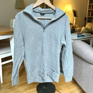 Massimo Dutti - Grå Half-zip Tröja  - Grå långärmad tröja från Massimo Dutti med half zip-dragkedja och hög krage. Härlig att dra över skjortor eller T-shirts når det är lite kallare. För liten för mig som är storlek M men perfekt för storlek S. I mycket bra skick. Tröjan är i 100% Bomull. Hör av dig gärna om du har frågor! 