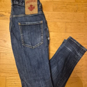  Dsquared2 Jeans - Snygga blå jeans från Dsquared2 med klassisk femficksdesign. Har några design håll annars inga skador på byxorna.