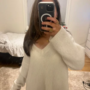 Vit stickad v-ringad tröja - (Reporna är på spegeln) Mysig vit stickad tröja med v-ringning och långa ärmar. Tröjan har en loose passform och är ribbstickad för extra struktur. Perfekt för alla outfits och mys dagar. Superenkel att matcha med jeans eller kjol. 🤍