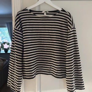 Randig stickad tröja från H&M - Säljer en svartvit randig stickad tröja från H&M. Tröjan har lång ärm, rund halsringning och är i mjuk stickad bomull. Snygg till både jeans och kjol.
