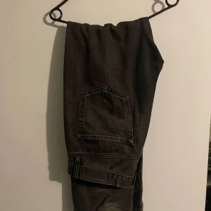 Svarta jeans från 157 Seattle - Säljer ett par svarta jeans från 157 Seattle med klassisk femficksdesign och raka ben. Jeansen har hög midja och är tillverkade i kraftig denim. Snyggt slitna detaljer och en cool vintagekänsla. Perfekta för dig som gillar en avslappnad och tidlös stil.