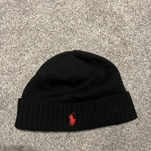 Svart Ralph lauren mössa - Svart mössa från Ralph lauren i one size. Perfekt nu till vintern när det börjar bli kallt