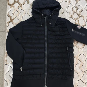 Svart Moncler pufferjacka med huva - Premium kvalitet, har använts få gånger och har inga defekter. OBS: bilderna kan se suddigt ut!