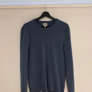 Blå Kashmir tröja från H&M - Fin blå kashmir tröja från H&M i regular fit. Tröjan har rund halsringning och långa ärmar, perfekt för lager-på-lager under kyliga dagar. Enkel och stilren design som funkar till det mesta. Tröjan är i kashmir och nypris är 1000kr 
