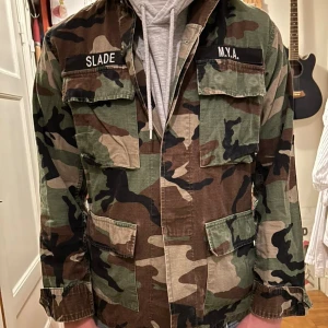 Camouflage overshirt från Propper - Säljer en militärinspirerad camouflage overshirt från Propper. Jackan har klassiska bröstfickor med namnlappar, fyra fickor framtill och stängs med knappar. Färgerna är grönt, brunt, svart och beige. Perfekt för hösten.