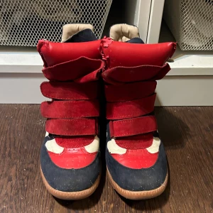 Isabel Marant skor - Isabel Marant skor i Röd, vinröd och marinblå färg. Skit snygga men passade inte mig så bra. De är lite dammiga så kommer rengöra de men de är också lite slitna på sidan av kudden men annars inget som förstör skorna eller fläckar. Storlek 38 skit snygga! (Har inga äktighets kvitton för jag köpte de på vinted) Men skulle säga att de ser äkta ut och verkar äkta efter det jag letat efter på nätet:)