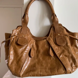 Brun vintage väska  - Helt nu oanvänd vintage väska med äkta skinn, bra utrymme 