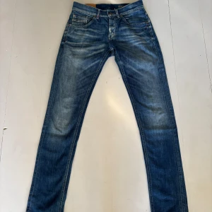 Dondup blå Ritchie, stl 30 - Snygga blå jeans från Dondup i skinny fit-modell. Jeansen har klassisk femficksdesign, slitningar och tvättade detaljer för en cool look. Tillverkade i jeansmaterial med smal passform som sitter tajt längs benen.