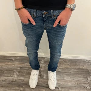 Slim jeans från Tiger of Sweden - Blå slim fit jeans från Tiger of Sweden med klassisk femficksdesign och snygga kontrastsömmar. Jeansen har en mellanblå tvätt och är tillverkade i bomullsdenim. Perfekta för dig som gillar en smalare passform och stilren look.