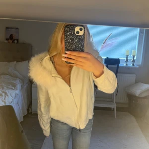 Vit stickad hoodie med päls - Superfin vit stickad hoodie med dragkedja och fluffig päls runt huvan. Tröjan har långa och ribbade ärmar. Perfekt för dig som vill ha en mysig och trendig look under kyliga dagar. Har endast använt denna jacka/kofta en gång då jag kände att det inte var min stil. Ny pris är 1500kr, köpt på maddeliva. Tveka inte vid frågor!💗