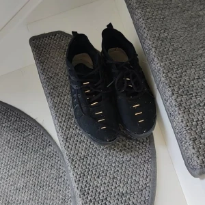  Nike vapor max  - Säljer ett par svarta Nike sneakers med snörning och coola detaljer på sidorna. Skorna har en robust sula och diskret Nike-logga baktill. Perfekta för dig som gillar sportig stil och vill ha bekväma skor till vardags.