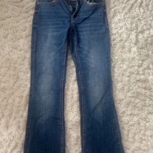 Blå bootcut jeans från Vero Moda - Snygga blå jeans från Vero Moda med klassisk bootcut-passform. Jeansen har normal midja och är tillverkade i mjukt denimtyg. Perfekta för dig som gillar en tidlös look med lite utsvängda ben. Dom är använda ca 1-2 gånger och är som nya