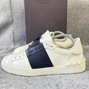 Valentino Opens - VALENTINO GARAVANI representerar den absoluta toppen av italiensk herrskomode, där avantgardistisk design möter tidlös maskulin elegans. Denna specifika modell, i den eftertraktade storleken 41 1/2, är ett exemplariskt bevis på husets förmåga att skapa ikoniska plagg som kombinerar kraftfull silhuett med raffinerad craftsmanship. Obs bara en ritning säljs. Skorna är omedelbart igenkännliga för sin distinkta karaktär, som balanserar mellan modern självförtroende och klassisk skärpa.