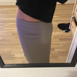 Beige långkjol från 157, XS - Snygg beige långkjol från 157 i storlek XS. Kjolen har en rak och tight passform som sitter högt i midjan och ger en clean siluett. Materialet är mjukt och stretchigt, perfekt för dig som gillar minimalistisk stil och neutrala färger.